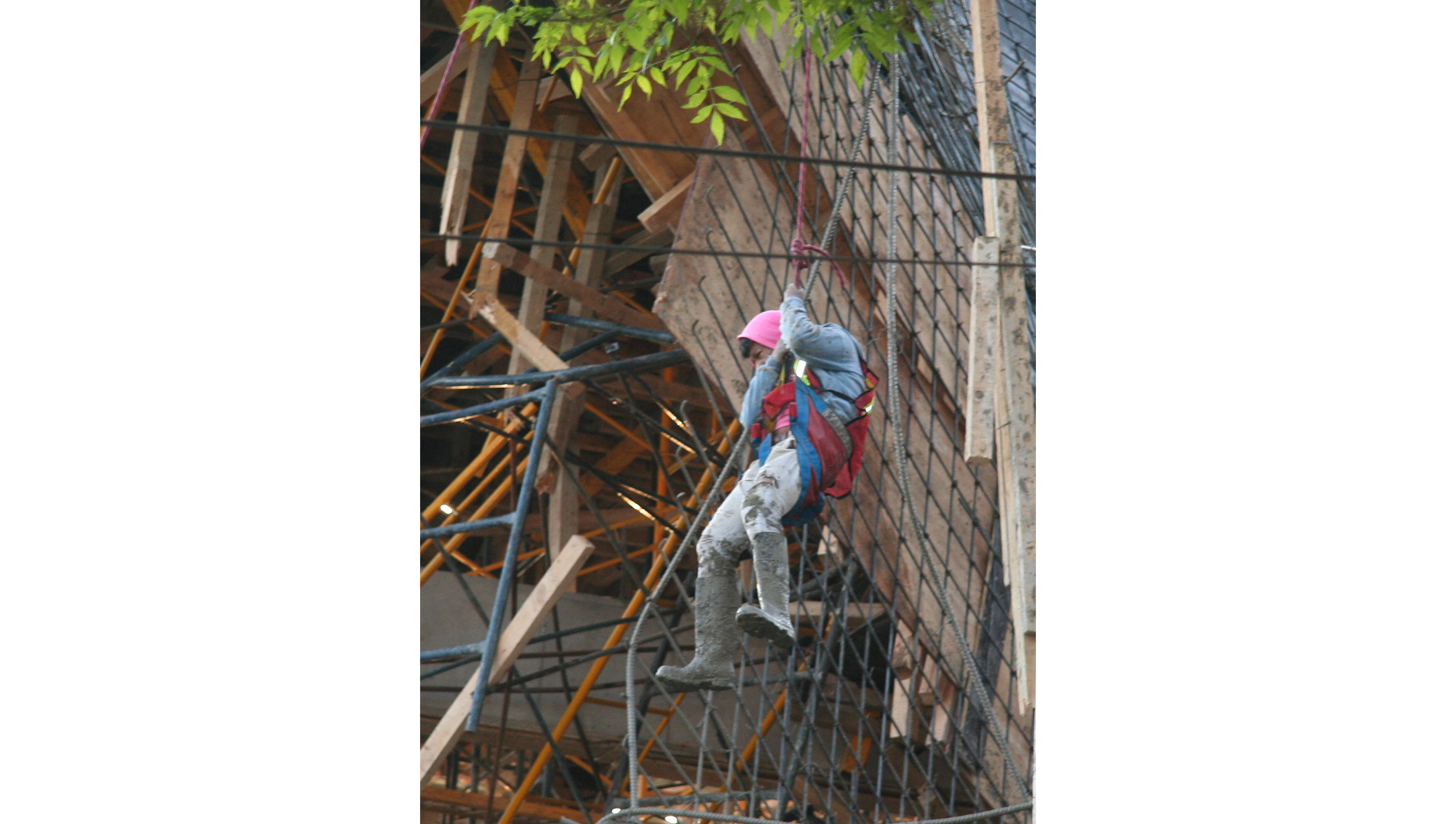 Un trabajador permanece colgado de varillas de acero. Foto/EFE<br>