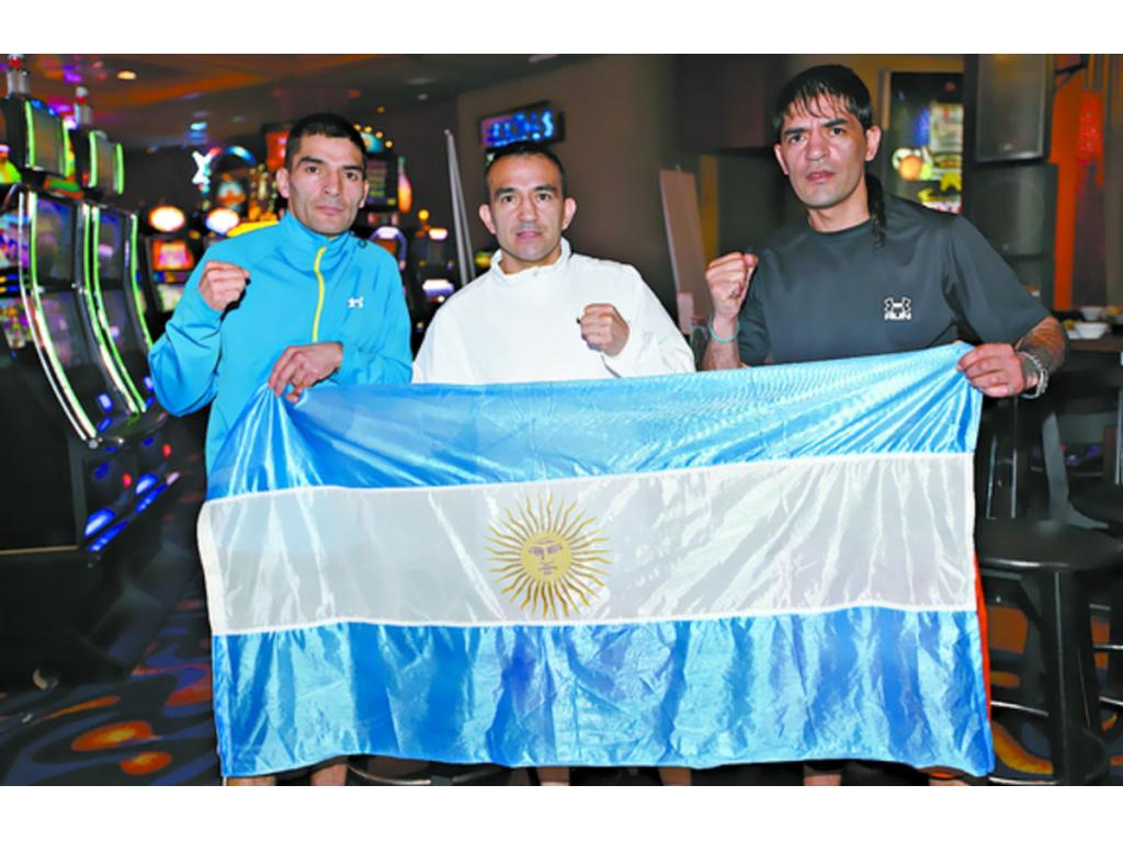 El retador Néstor Narváez (izq.) posó ayer muy orgulloso con la bandera de Argentina, junto con sus hermanos Omar (centro) y Mario. (Anayansi Gamez)