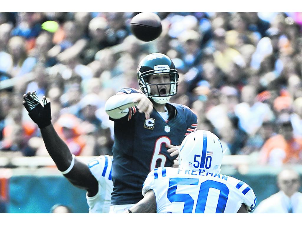 Aéreo. Jay Cutler (c) pasa el balón ante el acoso del rival.(EFE)