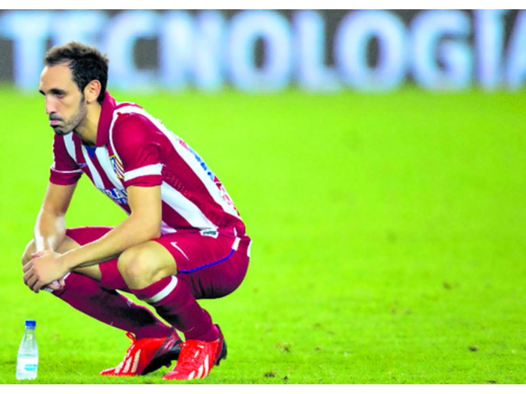El defensa del Atlético Juanfran mira con tristeza la celebración de los catalanes, después de que los madrileños no pudieran superar el marcador en contra.(Foto: EFE)