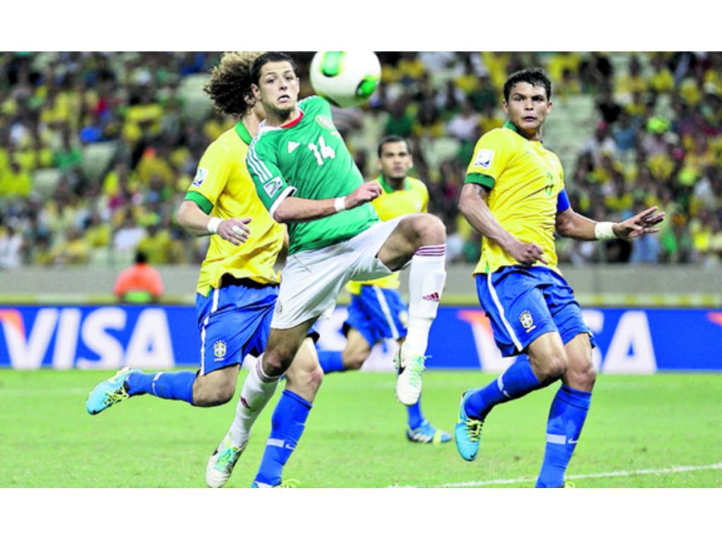 Javier Hernández (centro) intenta ganar el esférico ante los adversarios brasileños.(AP)