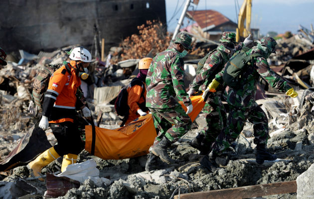 Los equipos de rescate retiran el cadáver de una víctima recuperada de entre los escombros por el terremoto y tsunami en Indonesia: EFE