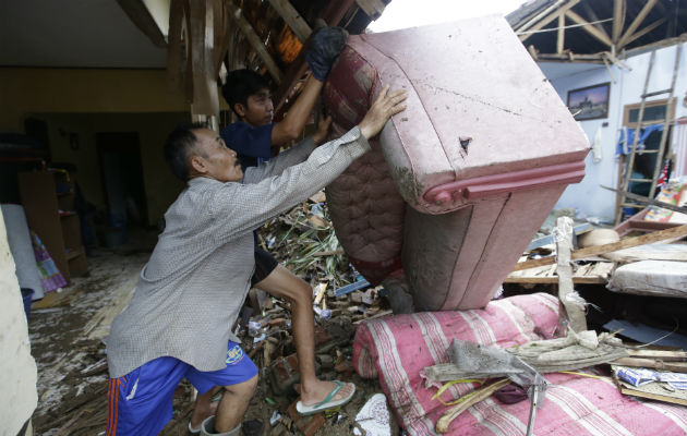 Los residentes limpian los escombros de las casas luego del tsunami en Carita, Indonesia. AP