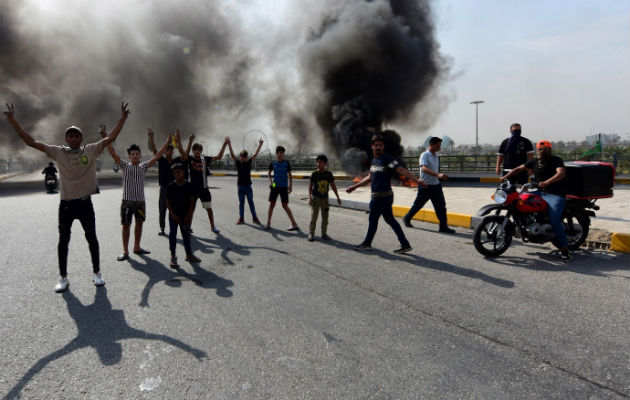 Manifestantes iraquíes queman llantas durante las protestas en Bagdad. Foto: EFE.