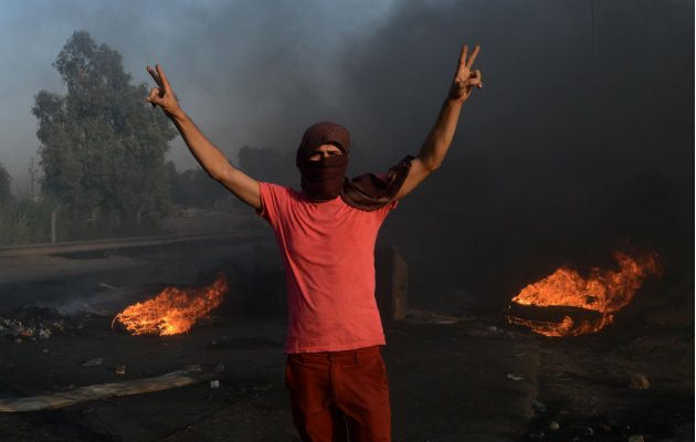 Durante el tiroteo, los manifestantes incendiaron llantas para hacer retroceder a los soldados. Foto: EFE.