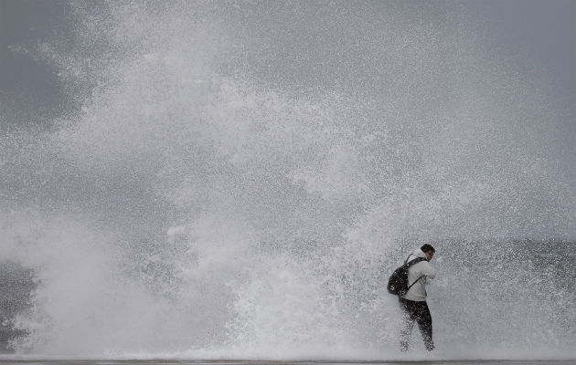 Un ciudadano desafía el fuerte oleaje en la playa de Barceloneta, durante el temporal marítimo que afecta a toda la costa catalana lo que ha obligado a activar la alerta naranja. Foto: EFE