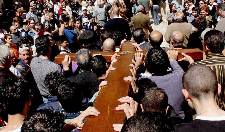 Un grupo de peregrinos lleva un cruz en su camino hacia la Basílica del Santo Sepulcro. Fotos: EFE