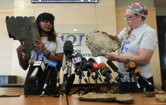 Grace Subathirai Nathan (i), hija de una víctima del vuelo MH370 de Malaysia Airlines, y Jacquita Gonzales, cuyo marido era un miembro de la tripulación, muestran dos piezas que podrían pertenecer al avión que desapareció. EFE