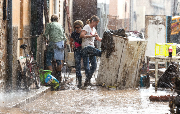 Los residentes colocan sus pertenencias dañadas en la calle bajo una lluvia torrencial, en Sant Llorenc, España. AP