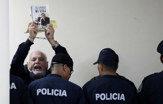 Policías empujan al expresidente Ricardo Martinelli para que no hable con los medios. Foto: Panamá América.