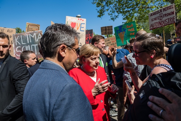 La canciller alemana, Angela Merkel (c), charla con activistas medioambientales durante la visita que realizó a la ciudad de Goslar, Alemania. FOTO/EFE