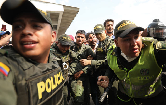 La policía colombiana escolta a un soldado venezolano que se rindió en el puente internacional Simón Bolívar. FOTO/AP