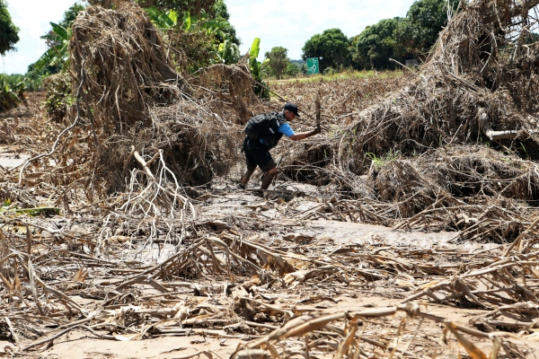 Stephen Fonseca busca cuerpos en un campo de maíz en ruinas en Magaru, Mozambique. FOTO/AP
