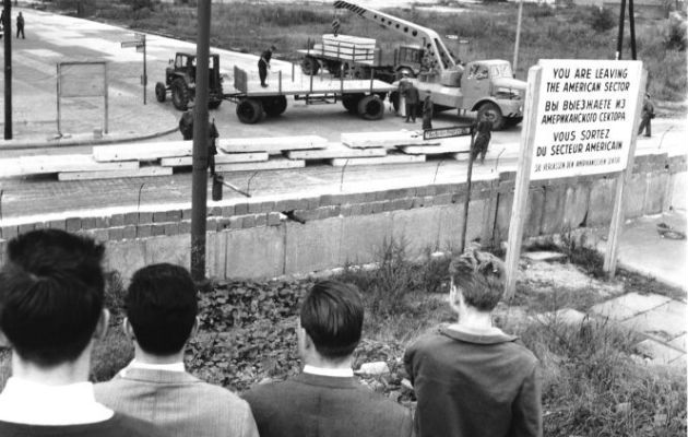 Berlineses del Oeste miran cómo los del Este descargan ladrillos para reforzar el Muro en Wilhelmstrasse, una importante calle de Berlín. Foto: AP.