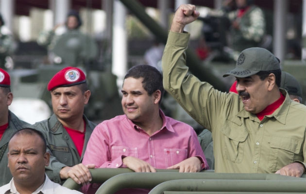 Nicolas Maduro Jr., centro, acompaña a su padre, Nicolás Maduro en una parada militar en Caracas, el 13 de abril de 2018. Foto: AP.  