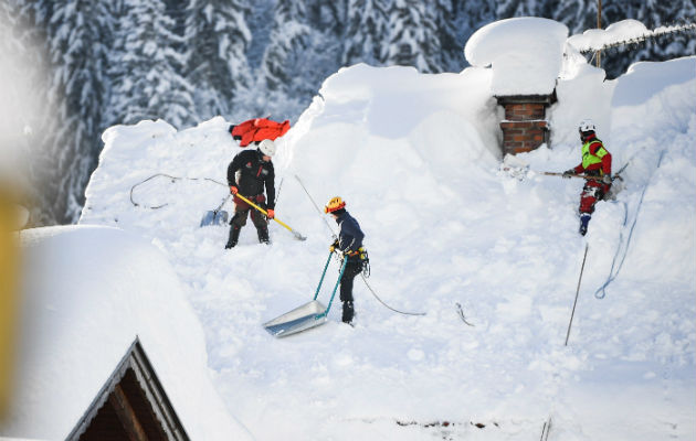 En Alemania, operarios retiran nieve de los techos. Foto: EFE.