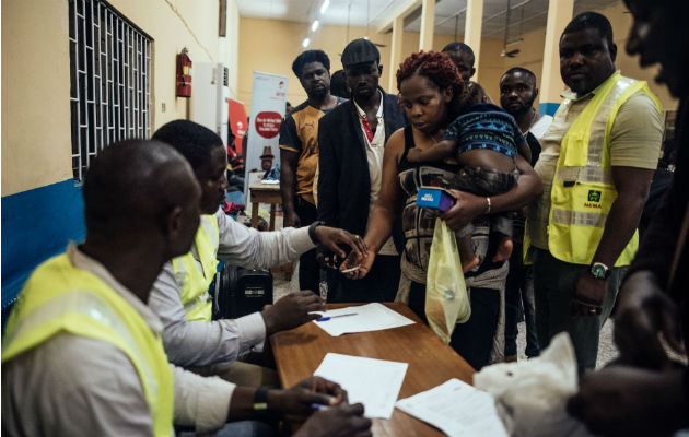 Una vez verificados sus documentos de viaje, los repatriados recibieron dinero del Gobierno nigeriano. Foto/ KC Nwakalor para The New York Times.