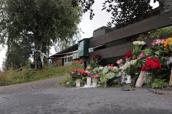 Las flores se encuentran al lado de la casa donde se encontró el cuerpo de la hermanastra de un presunto pistolero, en Baerum, Noruega.FOTO/AP