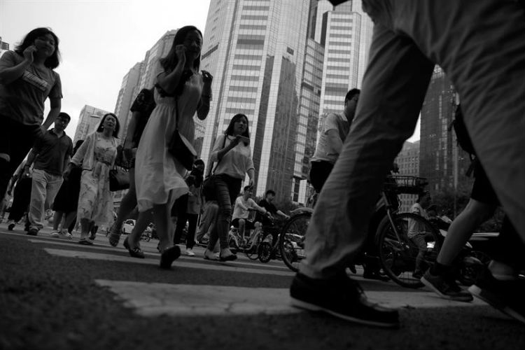 Peatones cruzan la calle en el Distrito Central de Negocios, en Pekín (China). Foto: EFE