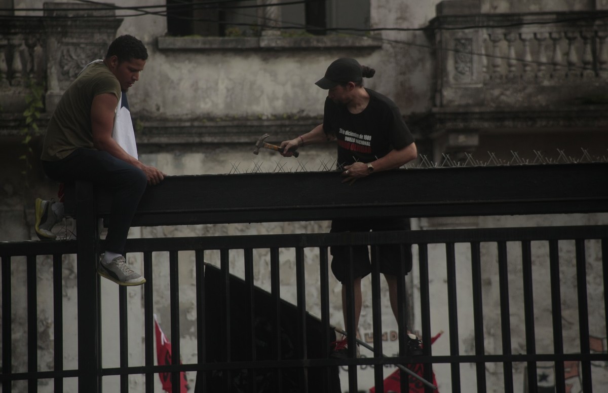 Los estudiantes quitan los alambres de púas que fueron colocados en la Asamblea Nacional. Foto Víctor Arosemena