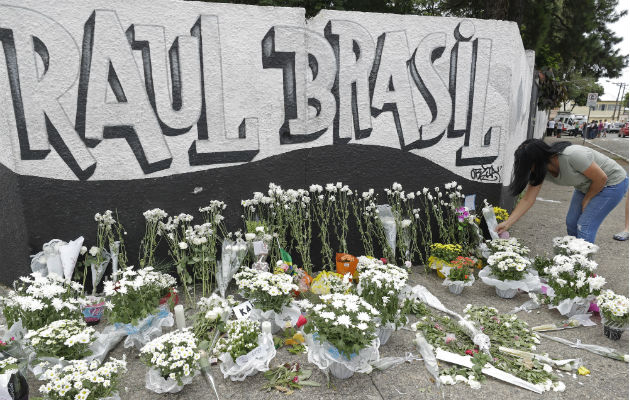 Una mujer coloca flores como tributo a las víctimas de la matanza en Suzano, Brasil. Foto: AP. 