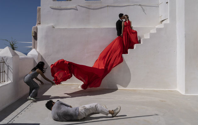 Tzuchi Lin y Yingting Huang llevaron múltiples atuendos a su sesión fotográfica previa a su boda en Santorini, Grecia. (Laura Boushnak para The New York Times)