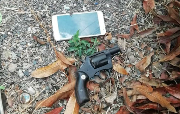 Revólver y un celular que fue arrojado fuera del penal. Foto: Eric A. Montenegro.