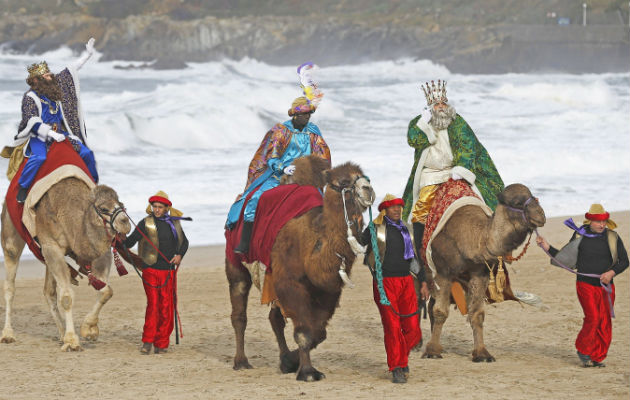 Los Reyes Magos a su llegada en camello a una playa del norte de España./ Fotos: EFE