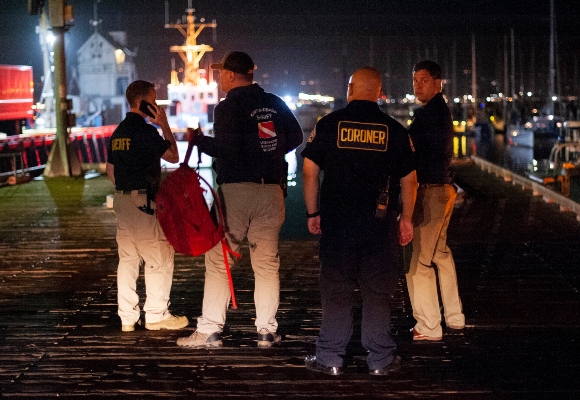 La policía local y los forenses trabajan para recuperar los cuerpos encontrados por los equipos de buceo después de un incendio mortal en el barco Concepción. FOTO/AP