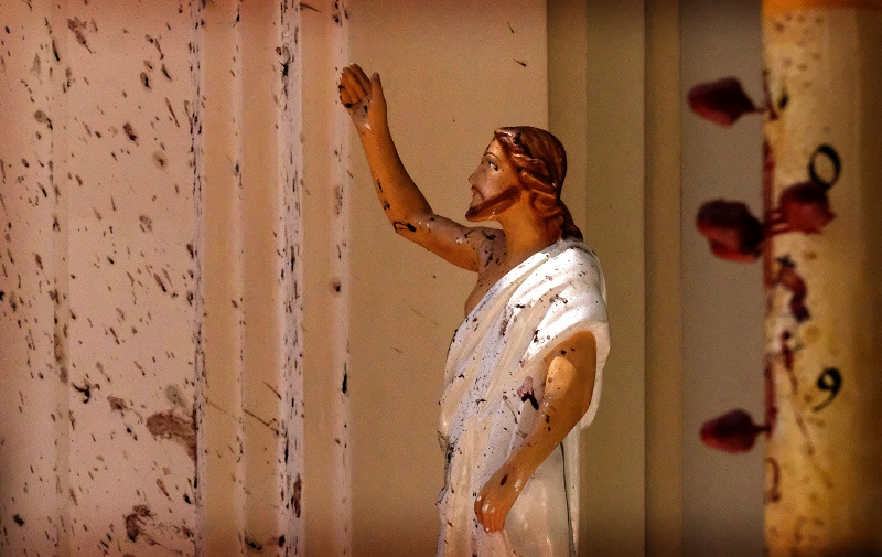 Manchas de sangre se ven en la pared y en una estatua de Jesucristo en la Iglesia de San Sebastián después de la explosión en Sri Lanka, hoy, domingo 21 de abril. Foto AP