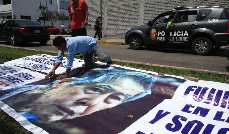 Simpatizantes del expresidente Fujimori traen una pancarta con su fotografía al exterior de la Clínica Centenario Peruano Japonesa.