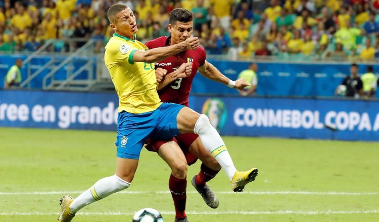 El jugador de Brasil Richarlison (i) disputa el balón con Yordan Osorio de Venezuela. Foto:EFE