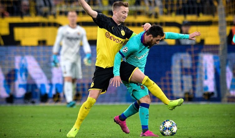 Marco Reus disputa (izq.) el balón ante Messi. AP