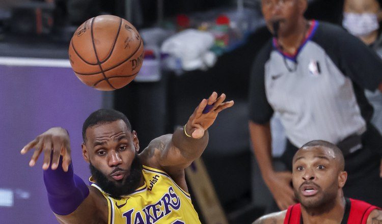 LeBron James (Izq.) de los Lakers, cede el balón ante la mirada de P.J. Tucker de los Rockets. Foto:EFE