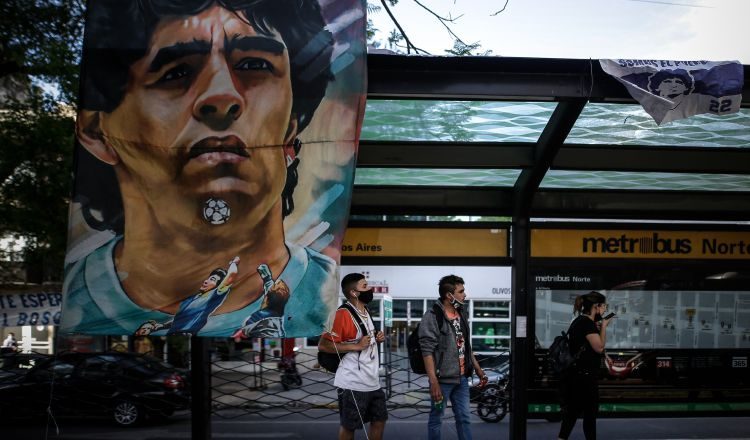 Carteles y banderas alusivas al exfutbolista y entrenador argentino Diego Armando Maradona cuelgan en una estación de bus cercana a la clínica Olivos. Foto:EFE