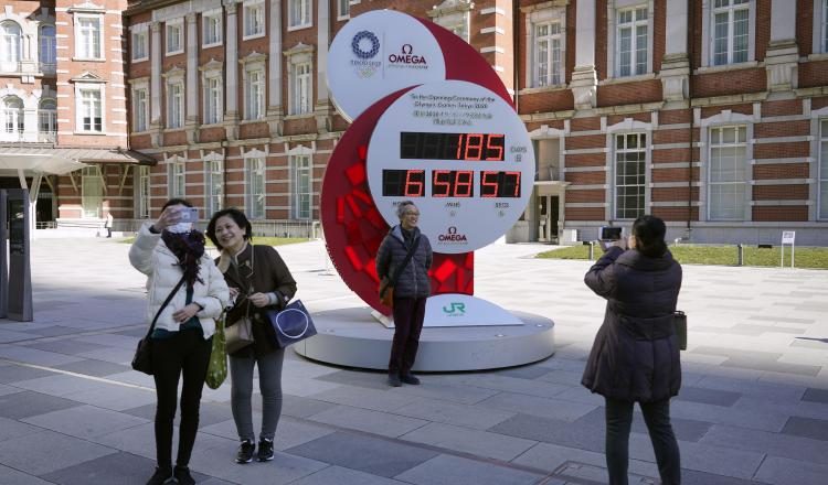 Los transeúntes posan ante un reloj de cuenta atrás de los Juegos Olímpicos. Foto:EFE