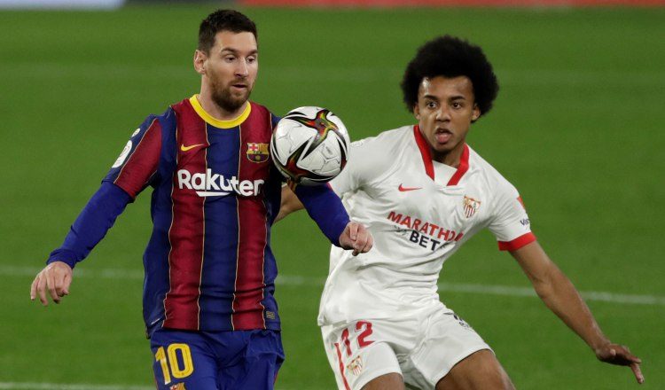 El defensa francés del Sevilla Jules Koundé (d) pelea un balón con el delantero argentino del Barcelona, Messi. Foto:EFE
