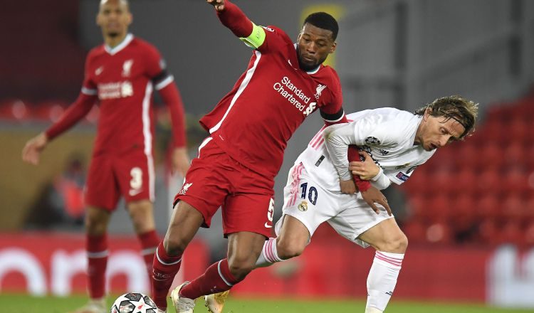 Georginio Wijnaldum del Liverpol es sujetado por Luka Modric del Real Madrid. Foto:EFE
