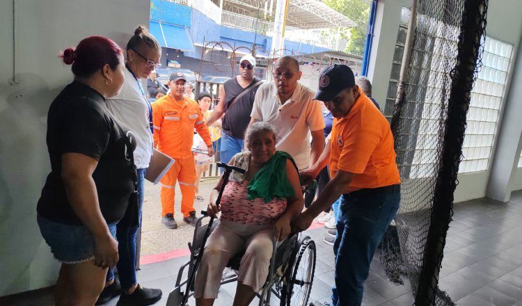 Personal del Sinaproc brinda asistencia a una mujer con movilidad reducida. Cortesía