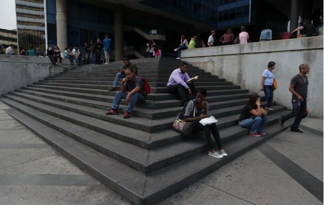 Venezolanos permanecen a la entrada de un edificio durante el apagón eléctrico en Caracas (Venezuela). Foto: EFE.