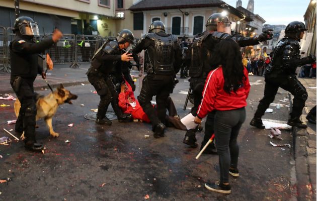 Policías se enfrentan a manifestantes durante una protesta de apoyo a favor del australiano Julian Assange, en Quito. Foto: EFE.
