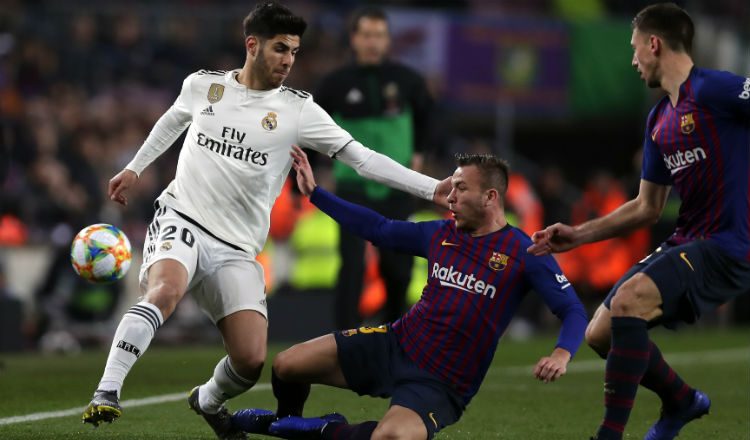 Marco Asensio de Real Madrid (izq.) es marcado por Arthur del Barcelona. Foto:AP