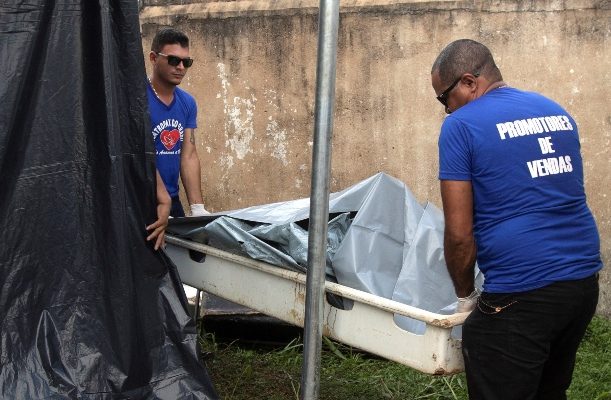 Dos hombre retiran uno de los cuerpos de las víctimas de la masacre en el Centro de Recuperación Regional de Altamira, en el IML (Instituto Legal de Medicina), en Altamira. FOTO/EFE
