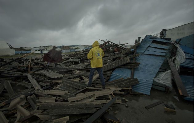 Un hombre camina sobre viviendas destruidas por el ciclón Idai en Beira, provincia Sofala en Mozambique. Foto: AP