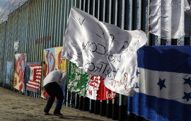 Un migrante hondureño frente a la valla entre Tijuana (México) y EE.UU. Foto: AP.