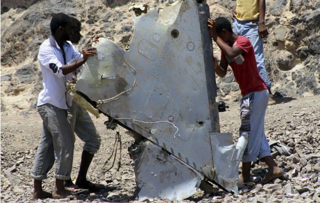Niños sostienen restos de la aeronave en Adén (Yemen). EFE