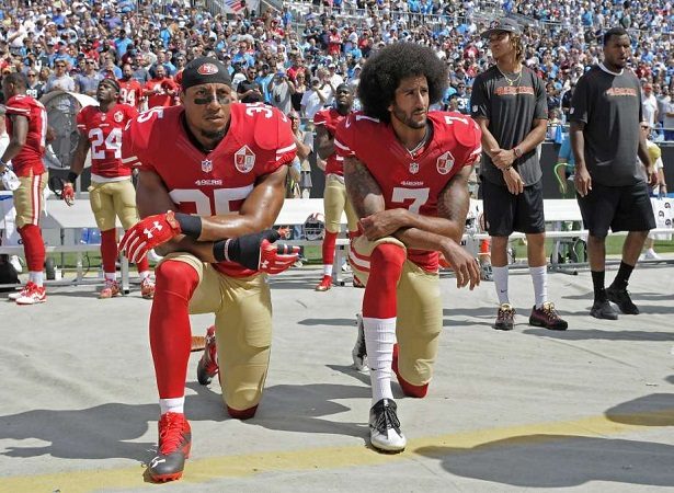Kaepernick  (dcha.) no permanecía de pie cuando sonaba el himno.