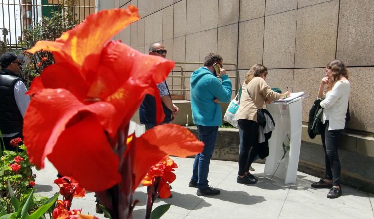 Personas escriben mensajes en honor a Julie Huynh. /Foto EFE