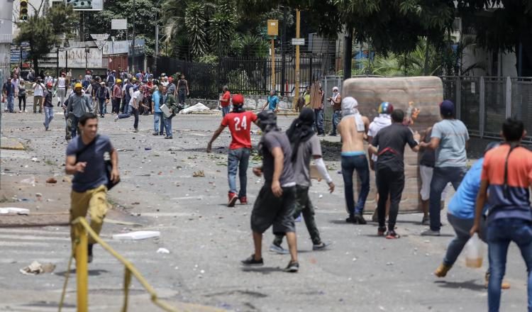 Manifestantes se enfrentan a la Guardia Nacional Bolivariana cerca de la TV estatal VTV en Caracas. EFE