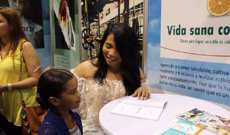 Sara Puello, en la XIII FIL de Panamá.  Dedica un libro y dialoga con una niña. Enfatiza que alimentarse bien empieza en el hogar. /Foto Micaela Melgar
